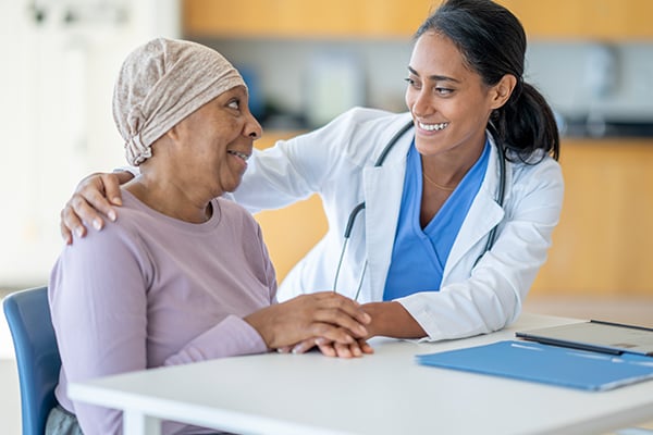 A chemotherapy patient and her doctor smiling about good news