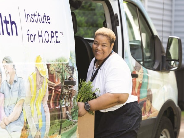 MetroHealth employee unloading a box of food from an Institute for HOPE van