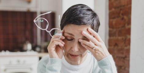 Woman holding glasses and head
