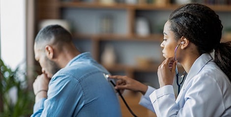 Man having his lungs examined by doctor with stethoscope