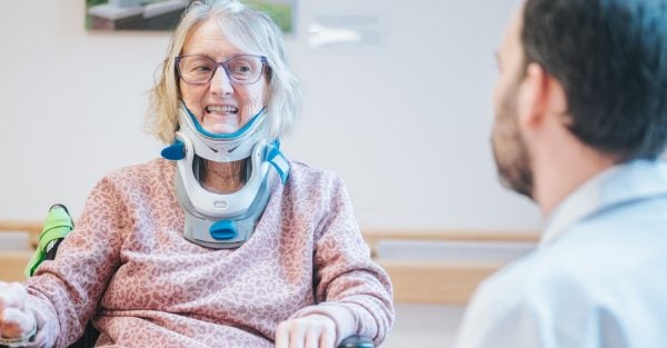 A smiling Rehabilitation patient with a neck brace