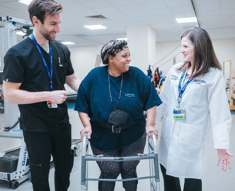 A Rehabilitation patient walking between two providers