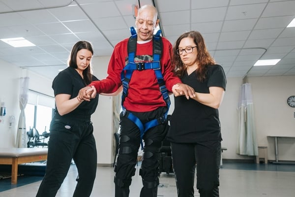 A Spinal Cord Rehabilitation patient walking with assistance
