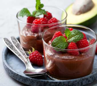 A bowl of chololate pudding topped with berries