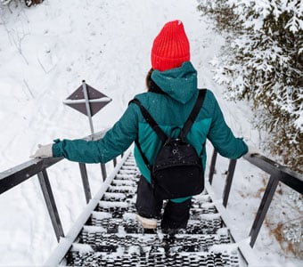 A person descending an icy outdoor staircase