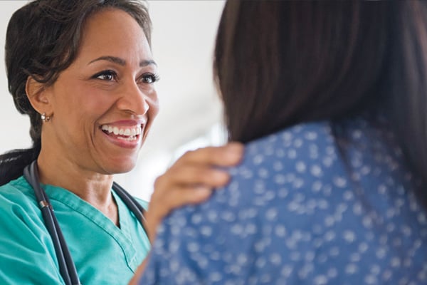 Provider with a reassuring hand on patient's shoulder