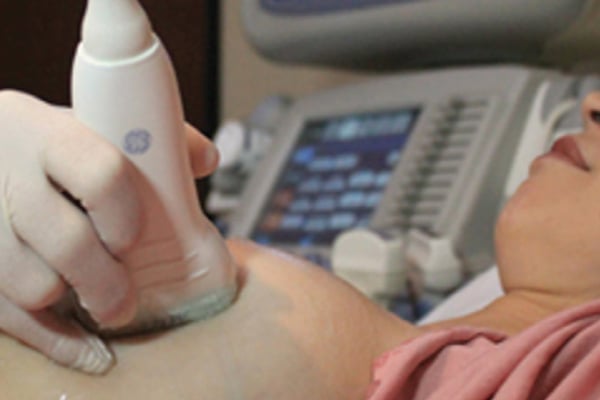 A provider performing a mammogram