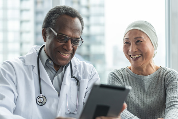 A chemotherapy patient and her doctor smiling at good news