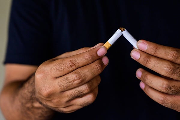 Person breaking cigarette