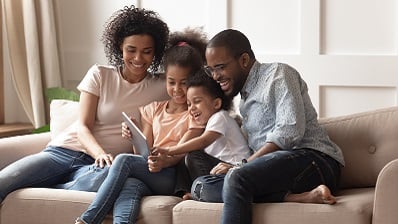 Family on couch reading a book