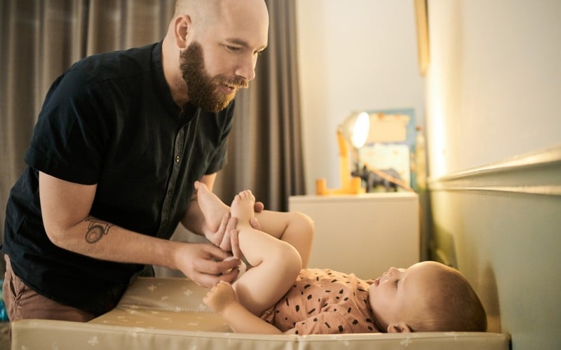 Dad changing baby's diaper