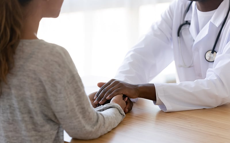 Healthcare provider holding patients hands