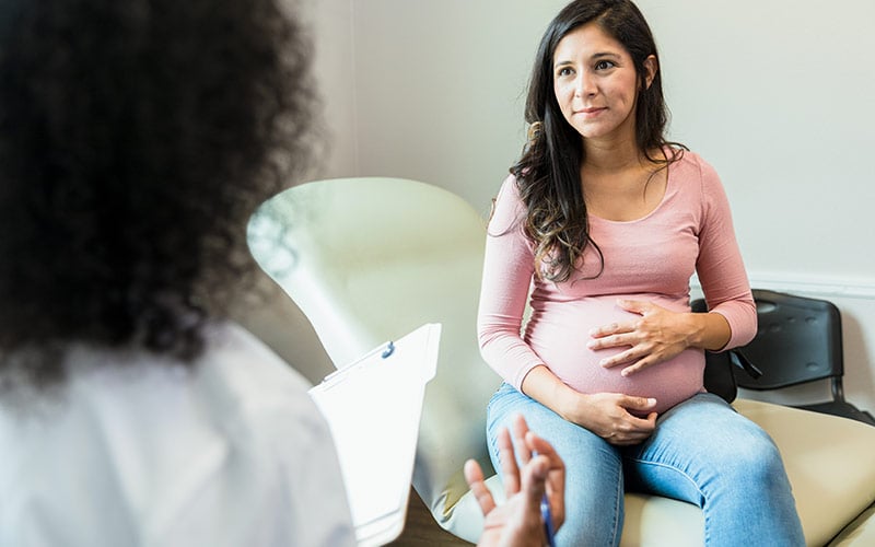 A pregnant mother talking with her doctor