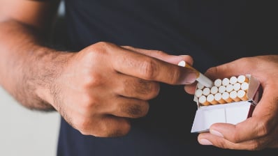 main holding pack of cigarettes