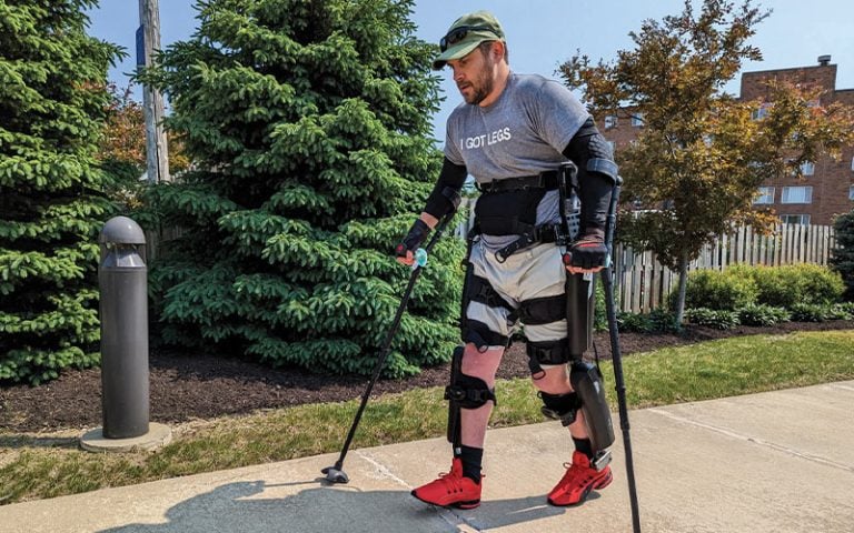 A patient walking outside with the aid of mobility equipment
