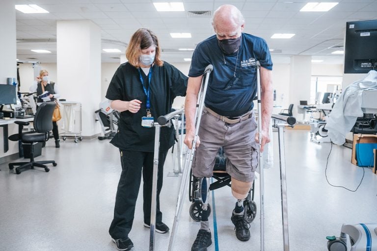 A Rehabilitation patient walking while monitored by a provider