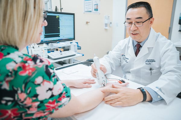 A Rehabilitation provider conducting an electromyography test on a patient's wrist